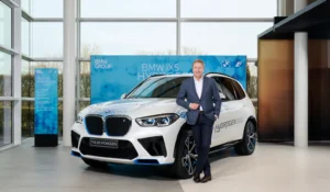 BMW Chairman Oliver Zipse stands next to the new BMW iX5 Hydrogen Fuel Cell vehicle