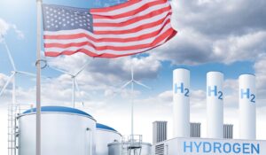American flag flying over a hydrogen facility and wind turbines amid clean energy funding cuts in the United States