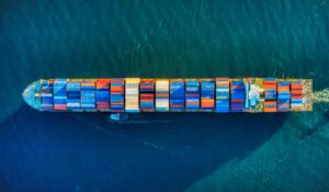 Aerial view of cargo ship at sea, representing clean hydrogen fuel for maritime shipping