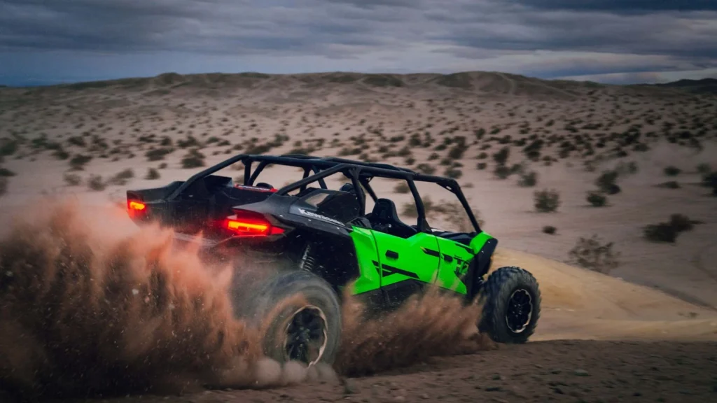 Rear view of Kawasaki Teryx H2 kicking up sand across the desert floor