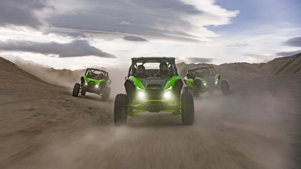 Three Kawasaki Teryx H2 vehicles kicking up dust during high-speed off-road run