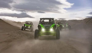 Three Kawasaki Teryx H2 vehicles kicking up dust during high-speed off-road run