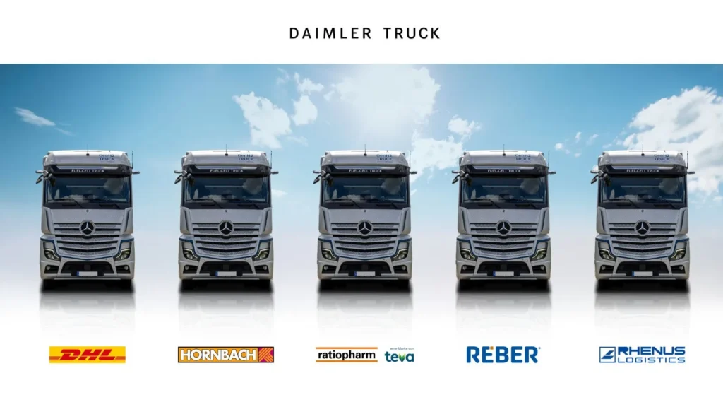 Five Daimler GenH2 fuel-cell trucks lined up with logos of DHL, Hornbach, ratiopharm, Reber and Rhenus Logistics beneath